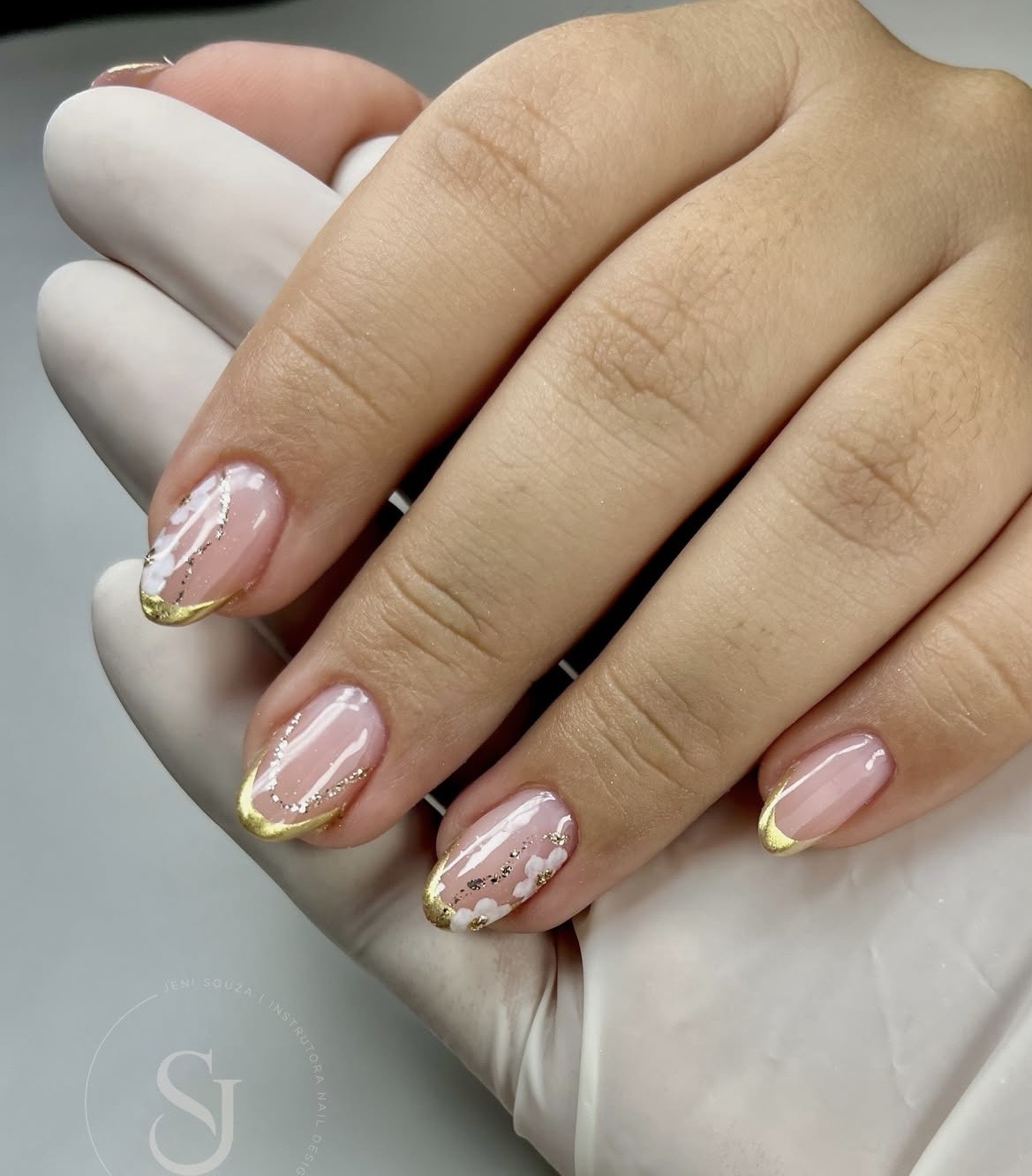 Unhas nude com francesinha dourada e nuvens brancas pintadas à mão