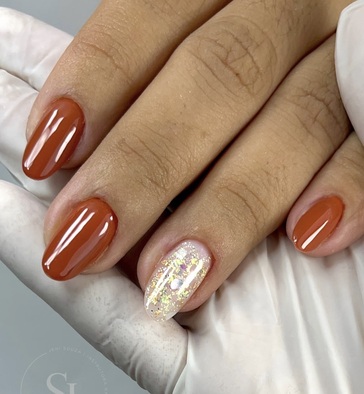 Unhas curtas terracota com unha decorada em glitter dourado